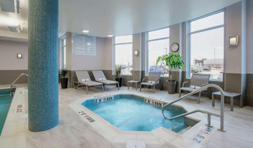 a swimming pool in a hotel lobby with chairs at Hilton Garden Inn Winnipeg South in Winnipeg