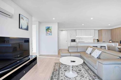 a living room with a couch and a table at 3 Bedrooms Apt in Glen Waverley central * parking in Glen Waverley