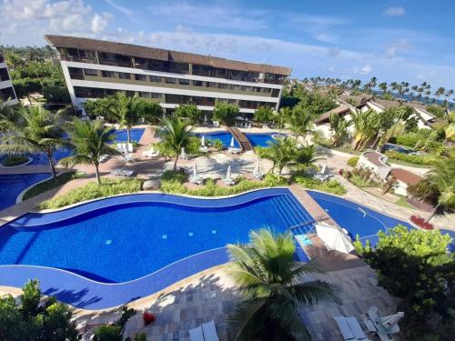 an aerial view of a resort with a swimming pool at Flat Duplex - Muro Alto Malawí in Porto De Galinhas