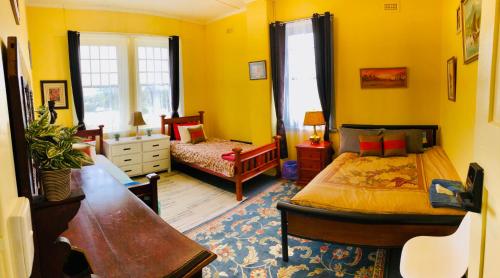 ein gelbes Schlafzimmer mit einem Bett und einem Sofa in der Unterkunft COMMERCIAL HOTEL KANIVA in Kaniva