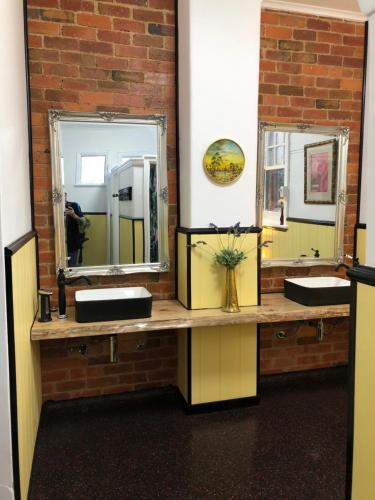 a bathroom with two sinks and two mirrors at COMMERCIAL HOTEL KANIVA in Kaniva