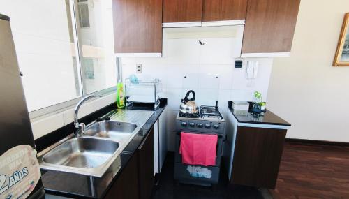 uma pequena cozinha com um fogão e um lavatório em Confortable y Amplio Apartamento Duplex en zona céntrica de Calacoto em La Paz