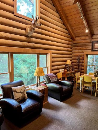 a living room with leather furniture and a deer head on the ceiling at Multi-Level Forest Lodge Near Silverwood with Vintage Ice Cream Parlor & Movie Theater in Spirit Lake