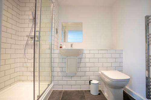 Baño blanco con lavabo y aseo en Contemporary 2 bedroom Apartment - Birmingham City Centre - Digbeth Bullring, en Birmingham