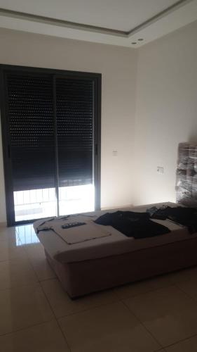 a bed in a room with a large window at A loué appartement in Agadir