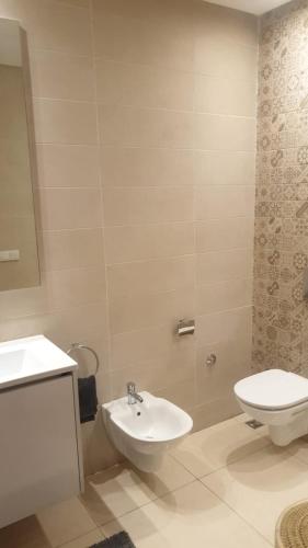 a bathroom with a white toilet and a sink at A loué appartement in Agadir