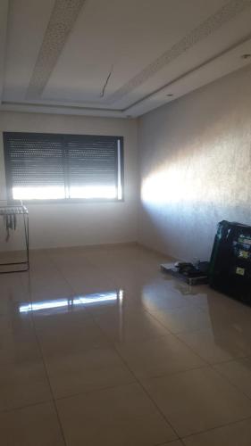 an empty room with a white wall and a window at A loué appartement in Agadir