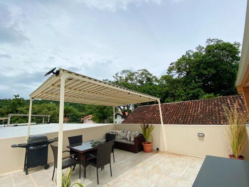 a pergola on the roof of a house at Charming Condo With A Rooftop, Across Beach in Coco