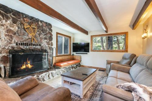 a living room with a stone fireplace and couches at Brand New 3BDR Cabin 4 Min to Ski Resort and Beach in Tahoma
