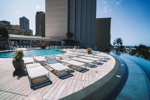 a group of lounge chairs and a swimming pool at Prince Waikiki in Honolulu