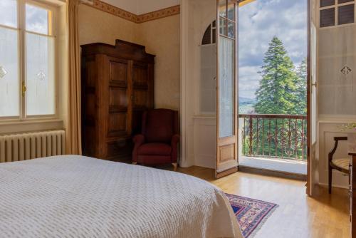 a bedroom with a bed and a chair and a window at Villa Volpe Como in Lanzo dʼIntelvi