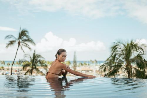 a woman in a swimming pool on the beach at Prince Waikiki in Honolulu