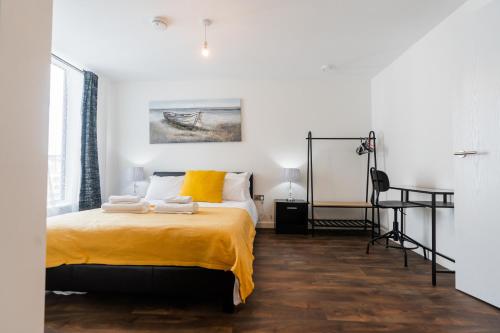a bedroom with a bed with a yellow blanket at Contemporary 2 bedroom Apartment - Birmingham City Centre - Digbeth Bullring in Birmingham