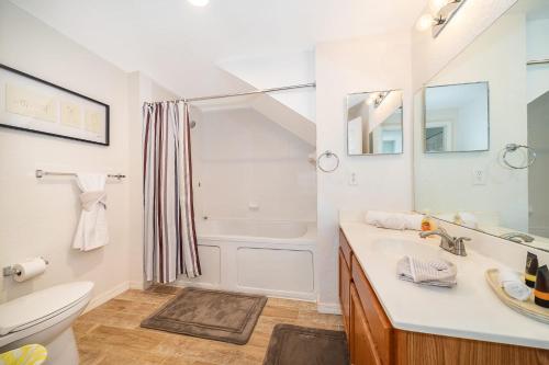 a bathroom with a sink and a tub and a toilet at Enchanted Townhome near Disney Parks 3Br in Kissimmee