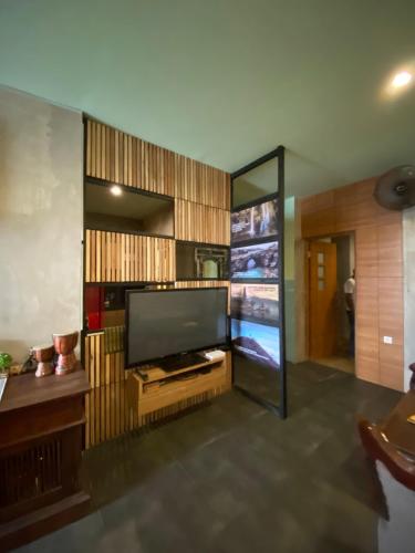 uma sala de estar com uma grande televisão de ecrã plano em Reddoorz Holistic Pod Hostel Kuta em Kuta
