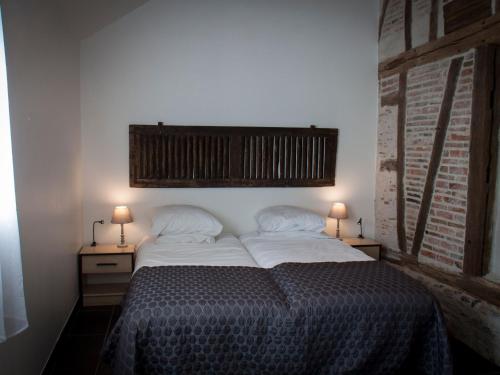 a bedroom with a bed with two lamps on two tables at Gîte spacieux avec piscine chauffée, wifi et tennis au bord de la Loire - FR-1-590-97 in Sigloy