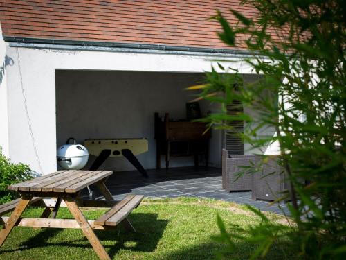 a backyard with a picnic table and a ping pong ball at Gîte spacieux avec piscine chauffée, wifi et tennis au bord de la Loire - FR-1-590-97 in Sigloy