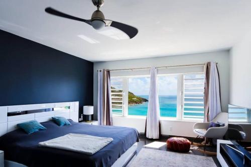 a bedroom with a bed and a large window at Blue Sanctuary in Koolbaai
