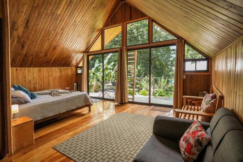 Tityra Lodge في مونتيفيردي كوستاريكا: غرفة نوم بسرير ونافذة كبيرة