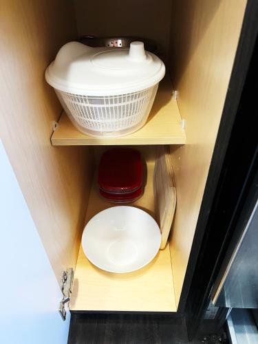 a cupboard with a bowl and a plate in it at Boutique Bliss in the Heart of Wortley Village in London