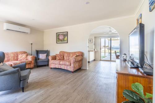 a living room with two couches and a television at Seabreeze on Ibis in Sussex inlet