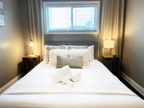 een slaapkamer met een groot wit bed en 2 handdoeken bij The Capri Suite in Old South London in London