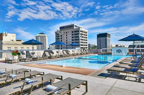 a pool with chairs and umbrellas on top of a building at Renaissance Montgomery Hotel & Spa at the Convention Center in Montgomery