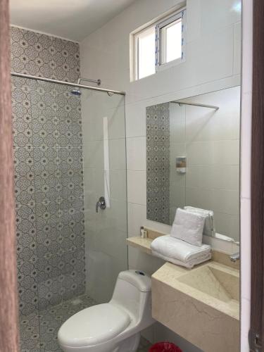 a bathroom with a toilet and a glass shower at Hotel Entre Lomas in Santa Rosa de Cabal