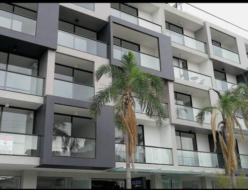 two palm trees in front of a building at Departamento en Equipetrol in Santa Cruz de la Sierra