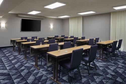 a conference room with tables and chairs and a screen at Courtyard by Marriott Memphis Airport in Memphis