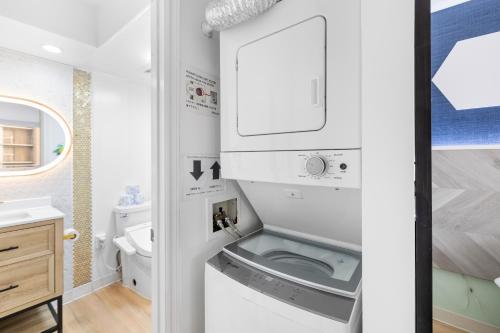 a small bathroom with a washer and dryer at Huge Patio WasherDryer 1 Bedroom Banyan Free Parking 5 min to Beach in Honolulu