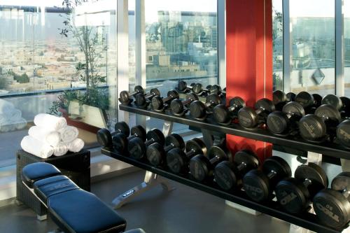 a gym with a bunch of dumbbells on a wall at Montreal Barsha Hotel in Dubai