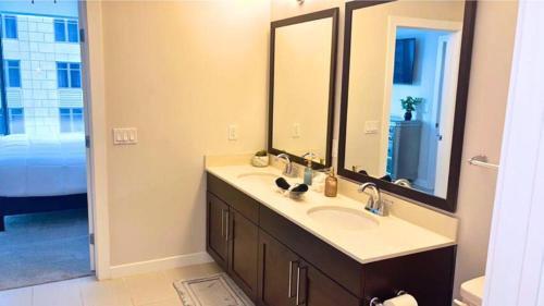 a bathroom with a sink and a large mirror at Blue Luxe-Highrise, Balcony, Pool, City View! in Atlanta