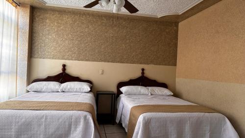 two beds sitting next to each other in a room at Hotel Palacio in San Juan de los Lagos