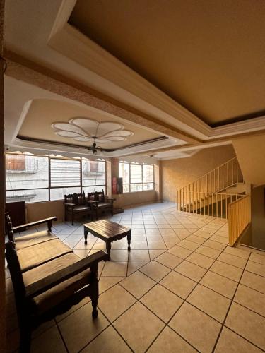 a room with a table and benches in a building at Hotel Palacio in San Juan de los Lagos