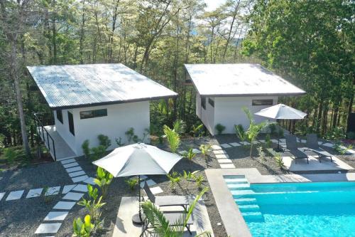 a resort with a pool and a house with umbrellas at Sharma Costa Rica- Mimosa Casita in Uvita