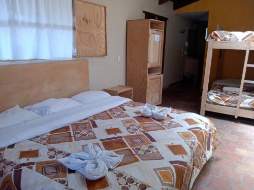 a bedroom with a bed with blue flowers on it at Rossco Hostel & Hotel in San Cristóbal de Las Casas
