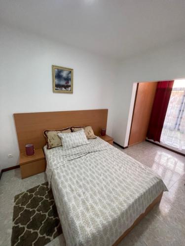 a bedroom with a large bed and a window at Isa House - Private Rooms in a Shared Duplex in Praia