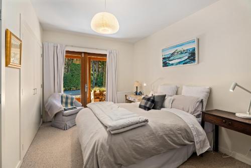 a bedroom with a bed and a desk and a window at Hāwea Lakehouse - Lake Hāwea Holiday Home in Lake Hawea