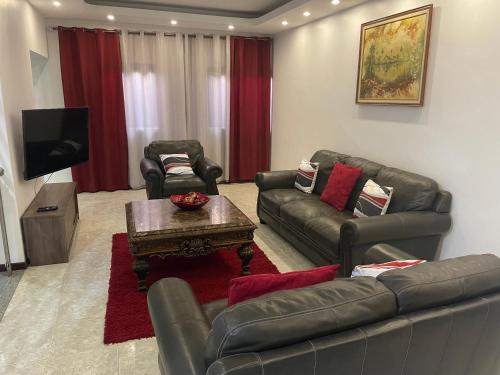 a living room with two leather couches and a tv at Isa House - Private Rooms in a Shared Duplex in Praia
