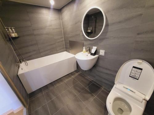 a bathroom with a toilet and a sink and a mirror at Hotel razaB in Pohang