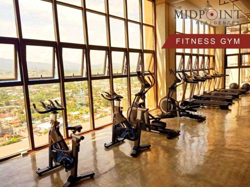 una fila de bicicletas estáticas en un gimnasio en 2 Bedroom Condo @ Midpoint Residences w/ City View, en Mandaue