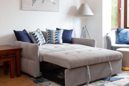 uma sala de estar com um sofá com almofadas azuis em Executive Apartment By Inverkeithing Train Station em Fife