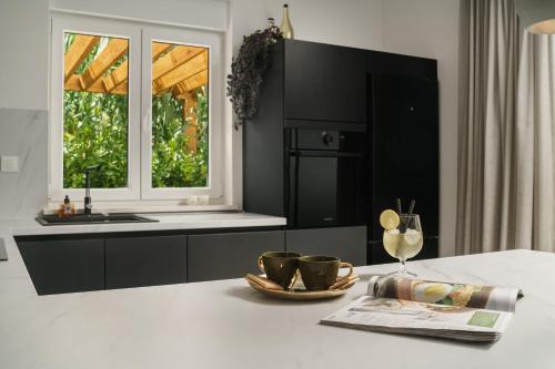 a kitchen with a table with two cups and a newspaper at Villa More Vodice in Vodice