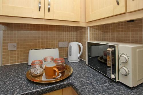 a kitchen counter with a plate of food and a microwave at Autumn Heights Apartments in Telford