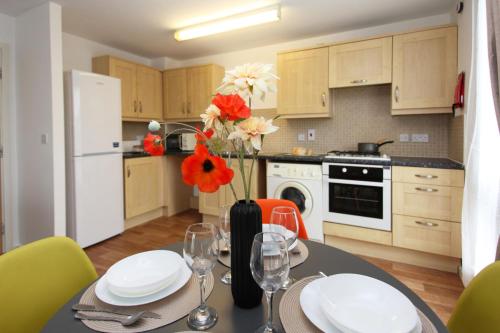 a kitchen with a table with a vase of flowers on it at Autumn Heights Apartments in Telford