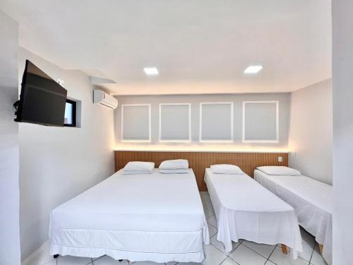Una habitación con dos camas y un televisor de pantalla plana. en POUSADA BEIRA MAR, en Fortaleza