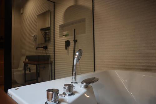 ein Waschbecken mit einem Wasserhahn und einer Badewanne in der Unterkunft Hani i Gjelit Hotel, Korce in Korçë