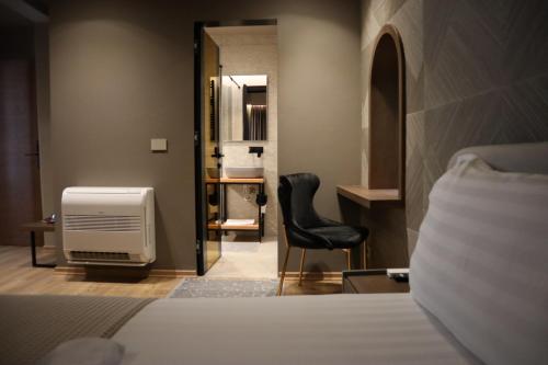 een slaapkamer met een bed, een bureau en een stoel bij Hani i Gjelit Hotel, Korce in Korçë