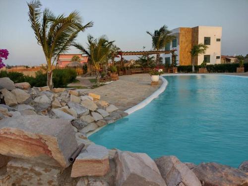 - une grande piscine dans un complexe avec des rochers dans l'établissement Chaleville 2301, Praia do maramar, luis correia, à Luis Correia